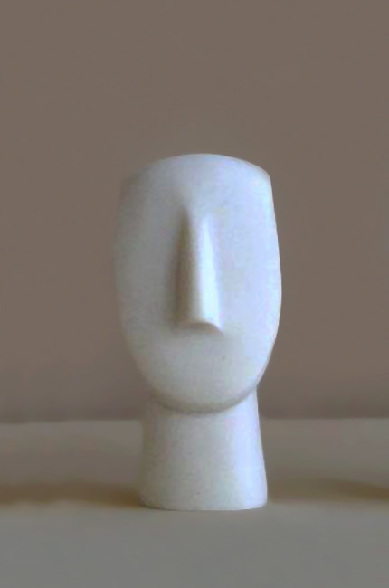 A statue of a face in Cycladic art type 2 in White color