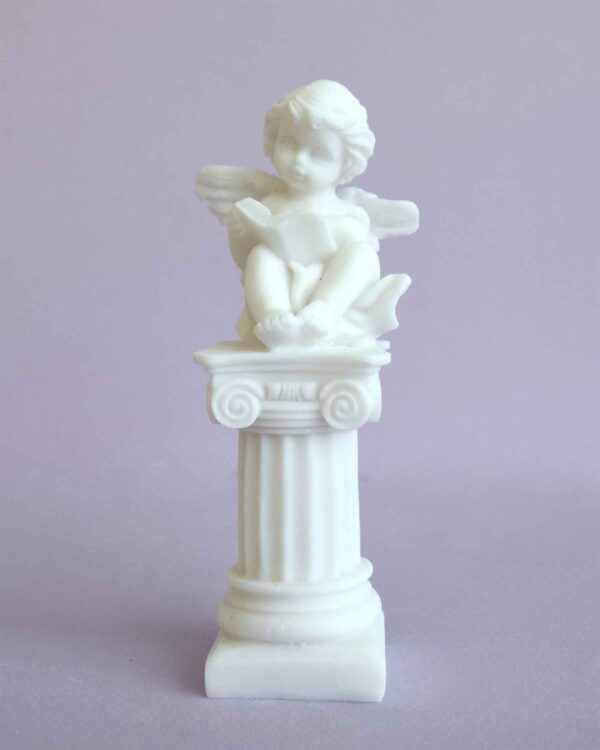 A statue of an Angel sitting on a column in White color
