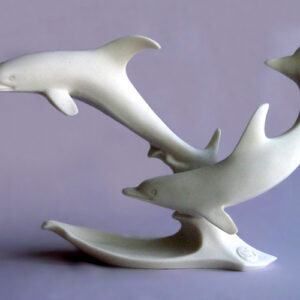 The statue of two dolphins swimming in White color