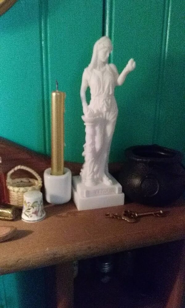 The statue of Hestia standing close to fire in White color
